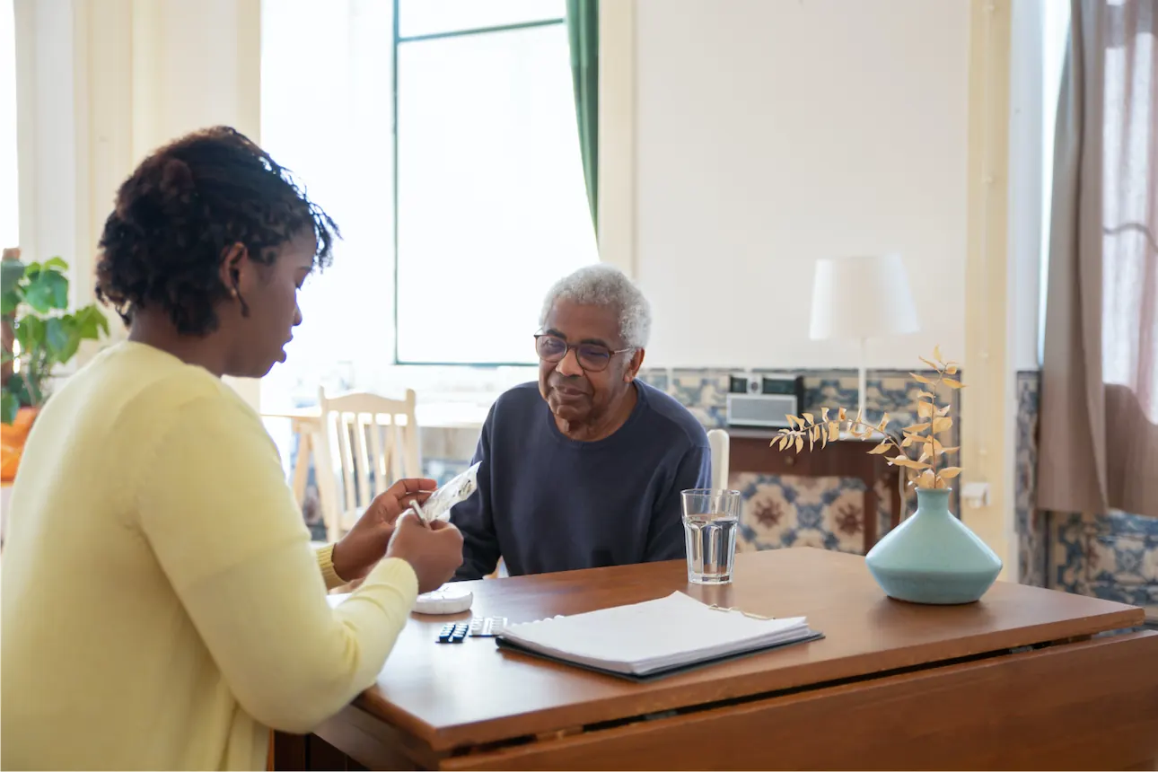 Carer and an elderly man reviewing his personalised support plan together at home