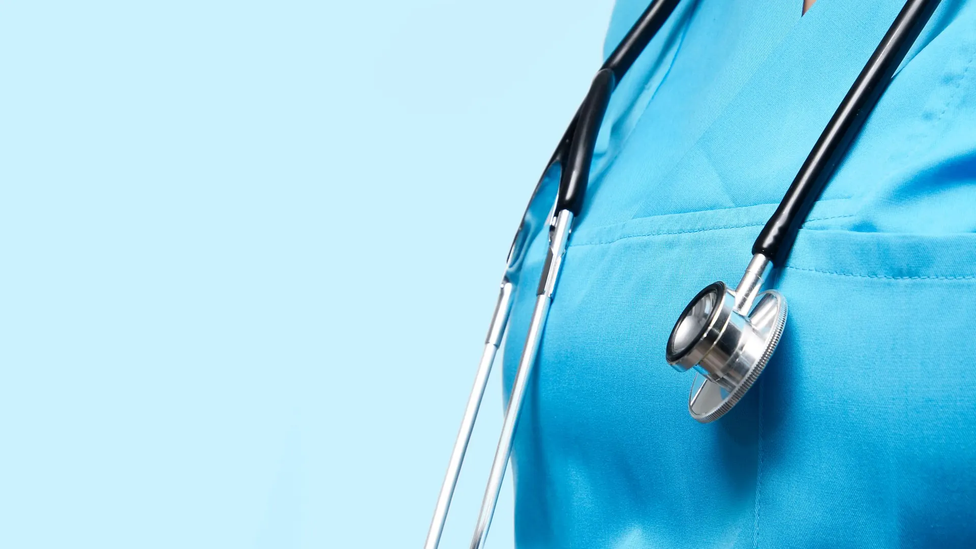 Care professional in blue scrubs with a stethoscope